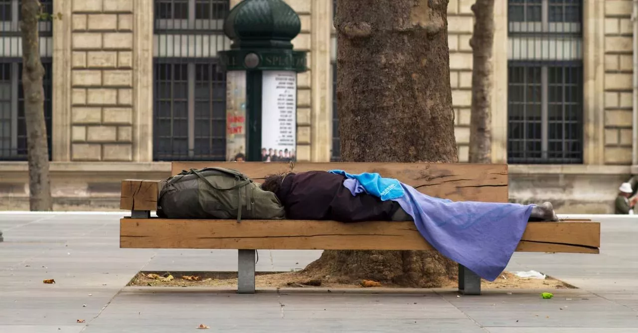 Homeless man sleeping on a park bench