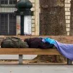 Homeless man sleeping on a park bench