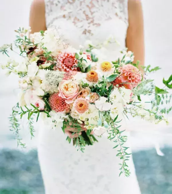 Bridal bouquet: A wild, asymmetrical bouquet including coral, peach, and salmon
