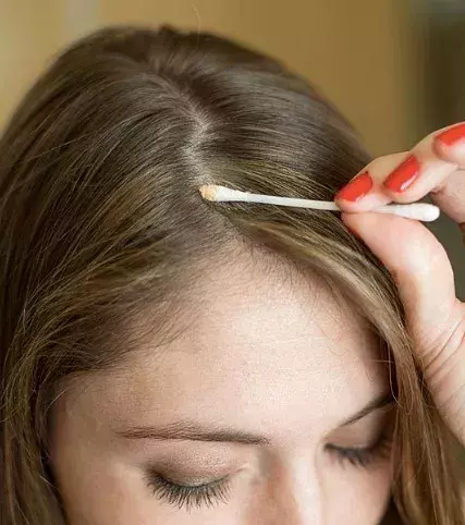 Use a cotton swab to help camouflage your roots. Dip the cotton swab into a mascara that is your hair shade then blend into your roots. This trick can also be used to help tame the stubborn hairs close to your roots.